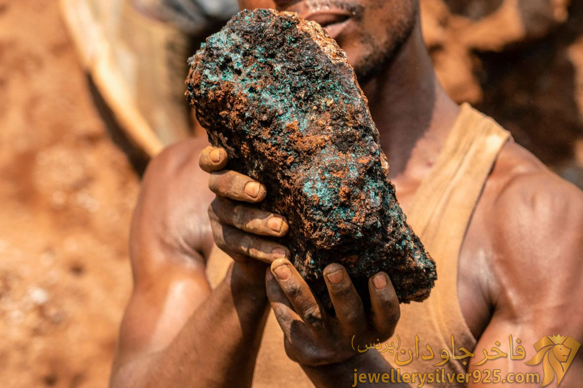 دلا وُمونگا، یک معدنچی صنعتگر، در 12 اکتبر 2022، سنگ کبالت را در معدن صنایع دستی شابارا در نزدیکی کولوزی نگه می دارد